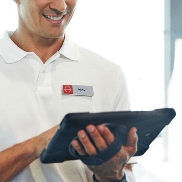 Person reviewing Nissan Business Fleet Courtesy Delivery customizations benefits on tablet