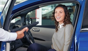 Woman Sitting In Driver Seat Smiling