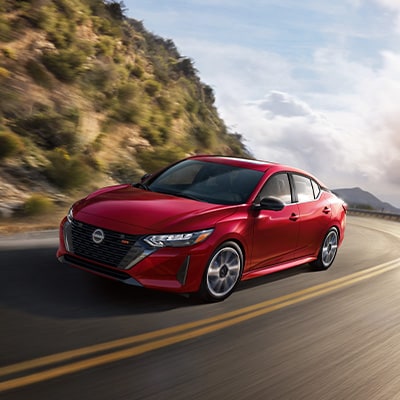 2024 Nissan Sentra in red taking a mountain curve at speed video.