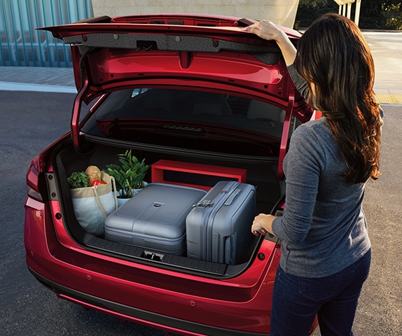 2024 Nissan Versa rear view of large, easy-access trunk with luggage and groceries inside