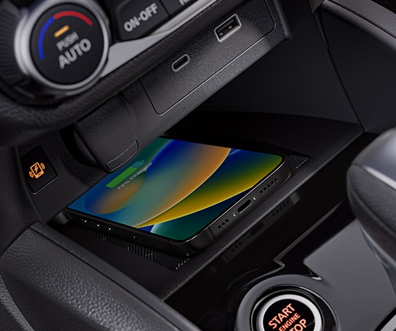 2024 Nissan Versa interior detail showing smartphone on wireless charger