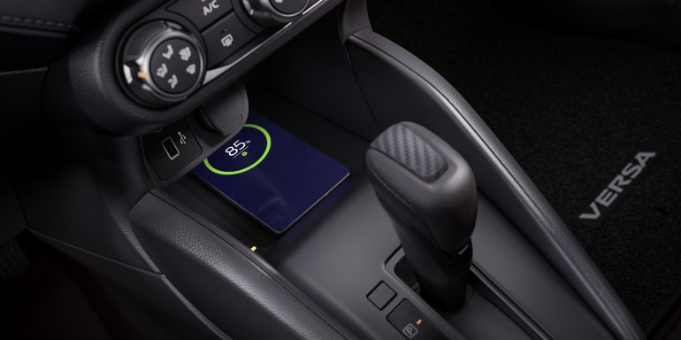 2024 Nissan Versa interior detail showing smartphone on wireless charger.